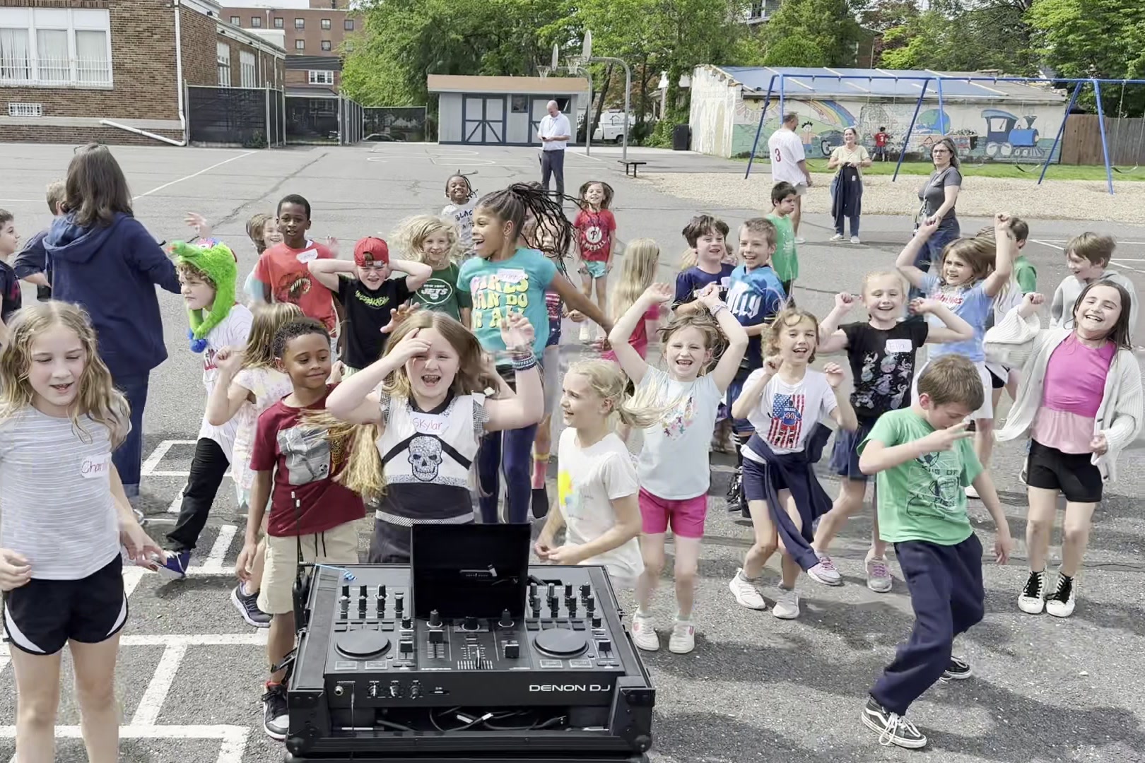 Kids dancing around the DJ at an outdoor party