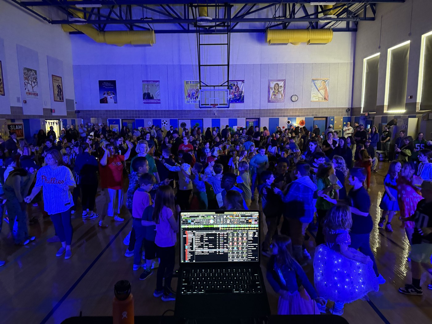 A school dance crowd under blue event lighting