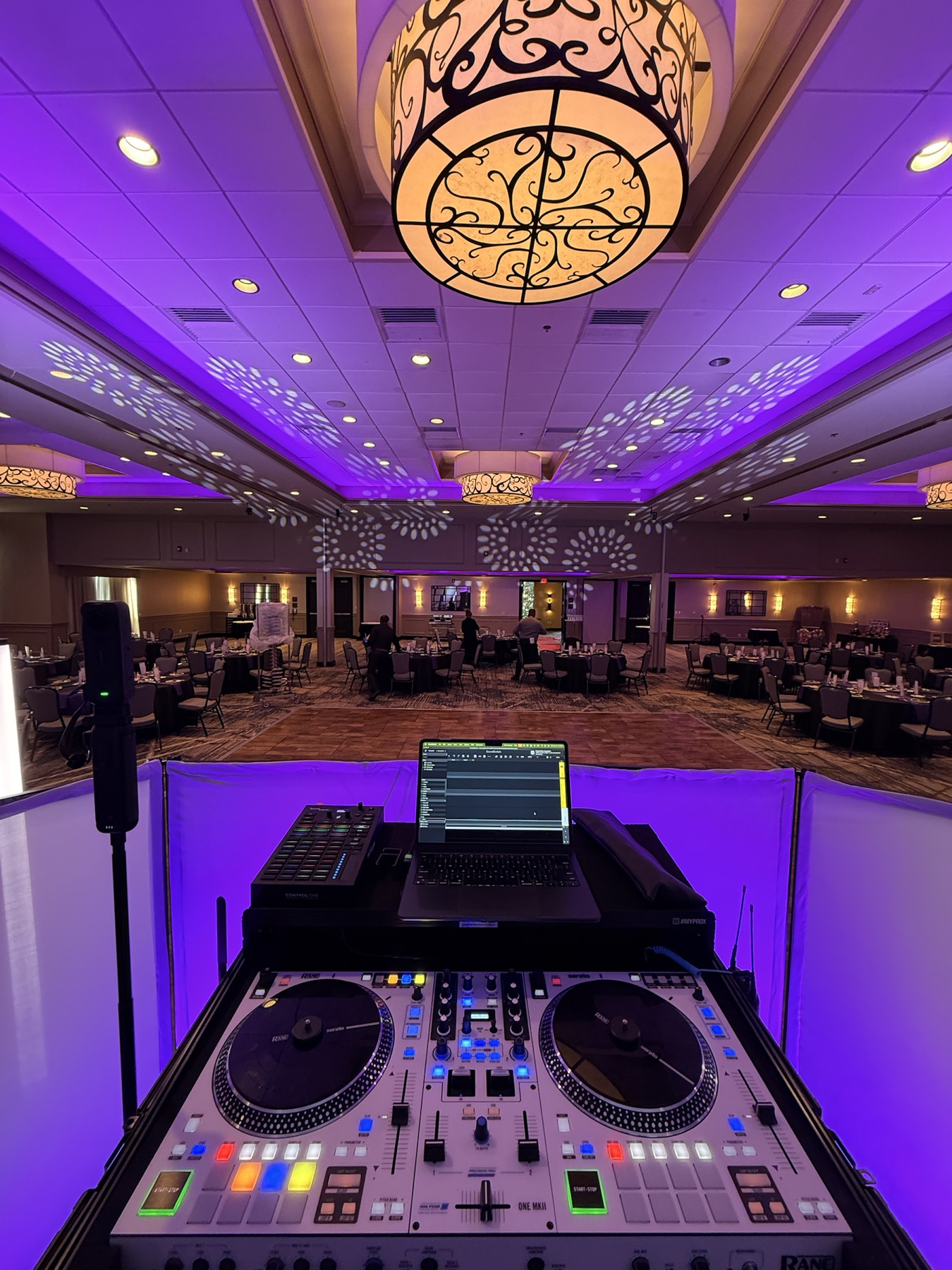 A complete DJ booth overlooking a ballroom before guests arrive